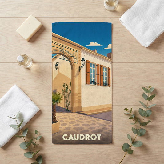 Serviette de bain souvenir de la ville de Caudrot avec une illustration stylisée d'une rue pittoresque.