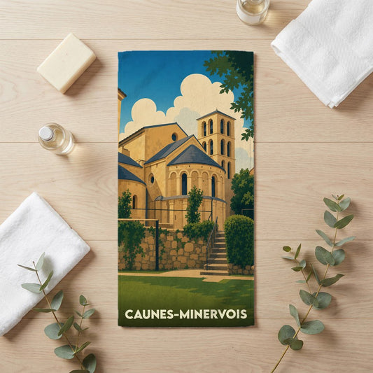 Serviette de bain souvenir de la ville de Caunes-Minervois avec une illustration stylisée de son abbaye.