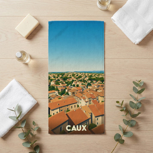 Serviette de bain souvenir de la ville de Caux avec une illustration stylisée des toits du village.