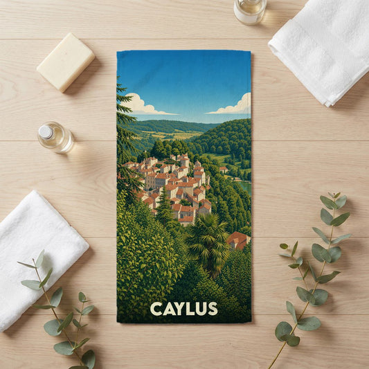 Serviette de bain souvenir de la ville de Caylus avec une illustration paysagère stylisée.