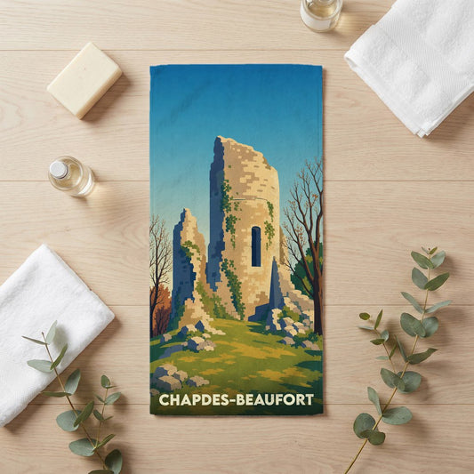 Serviette de bain souvenir de la ville de Chapdes-Beaufort avec une illustration stylisée de ruines médiévales.