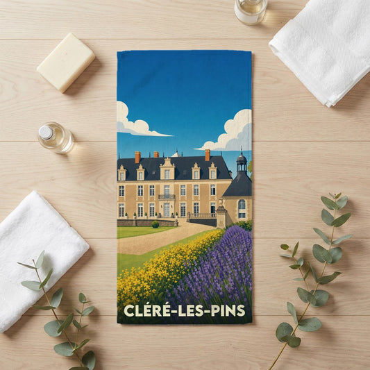 Serviette de bain souvenir de la ville de Cléré-les-Pins avec une illustration stylisée d'un château et de jardins.