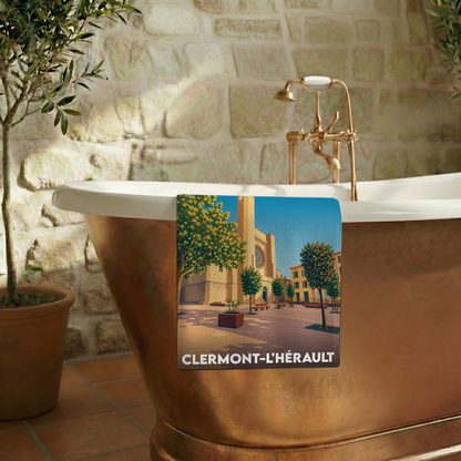 Serviette de bain souvenir de Clermont-l'Hérault avec une illustration stylisée de la ville.