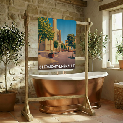 Serviette de bain souvenir de la ville de Clermont-l'Hérault avec une illustration stylisée de son église et de sa place.