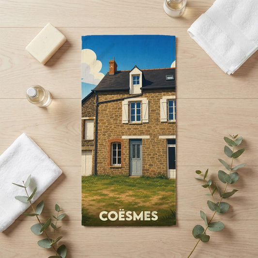 Serviette de bain souvenir de la ville de Coësmes illustrée d'une maison traditionnelle en pierre.