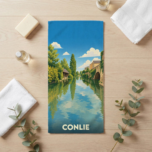 Serviette de bain souvenir de la ville de Conlie avec une illustration stylisée d'un canal bordé de maisons.
