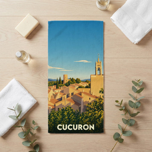 Serviette de bain souvenir de la ville de Cucuron avec une illustration stylisée de ses toits provençaux et de son clocher.