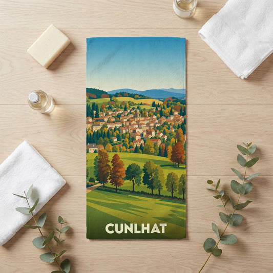 Serviette de bain souvenir de la ville de Cunlhat avec une illustration de paysage stylisée.
