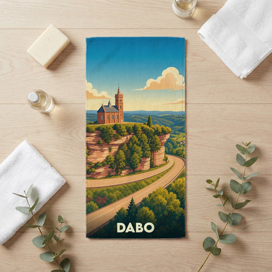Serviette de bain souvenir de la ville de Dabo avec une illustration stylisée de son rocher et sa chapelle.