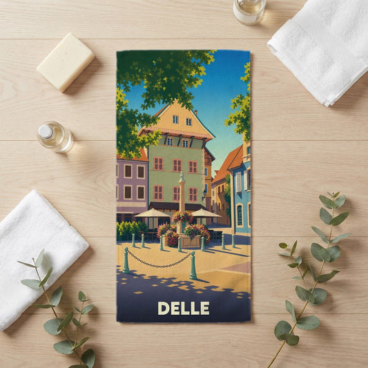 Serviette de bain souvenir de la ville de Delle avec une illustration colorée d'une place historique.