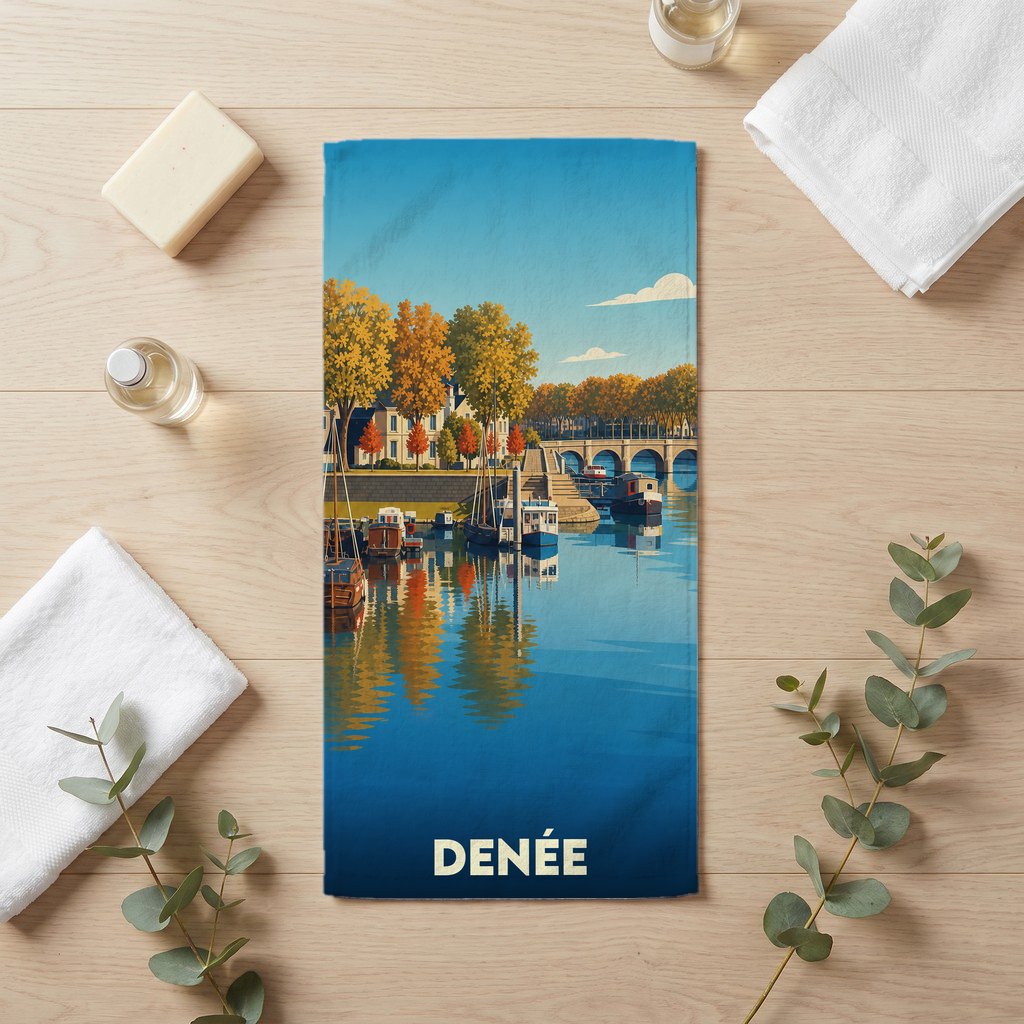 Serviette de bain souvenir de la ville de Denée avec une illustration stylisée d'un paysage de bord d'eau.