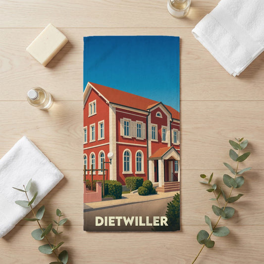 Serviette de bain souvenir de la ville de Dietwiller avec une illustration stylisée d'un bâtiment rouge.