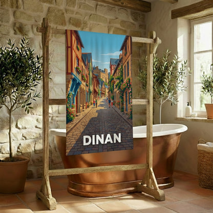 Serviette de bain souvenir de la ville de Dinan avec une illustration stylisée d'une rue historique.