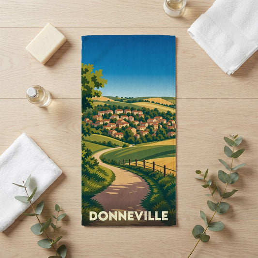 Serviette de bain souvenir de la ville de Donneville avec une illustration paysagère stylisée.