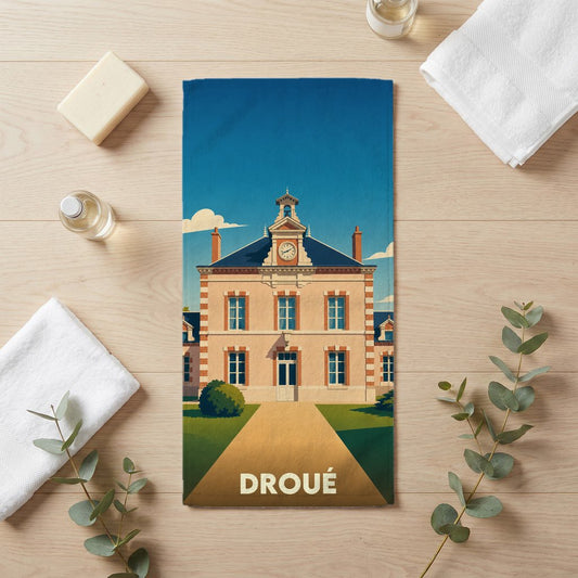 Serviette de bain souvenir de la ville de Droué illustrée d'un bâtiment de style classique avec un clocher.