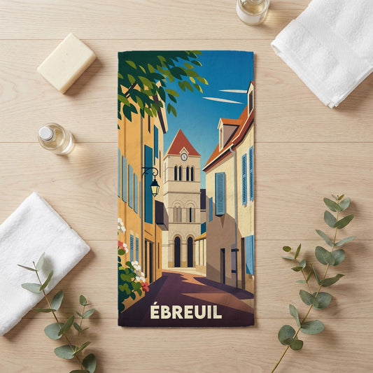 Serviette de bain souvenir de la ville d'Ébreuil avec une illustration stylisée d'une rue typique et son église.