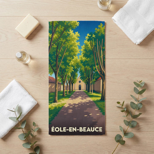 Serviette de bain souvenir de la ville de Éole-en-Beauce avec une illustration stylisée d'une allée arborée menant à une église.
