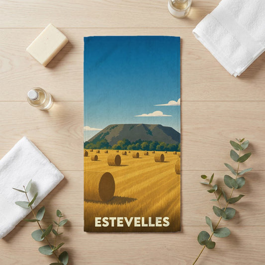 Serviette de bain souvenir de la ville d'Estevelles avec une illustration stylisée d'un champ de foin.