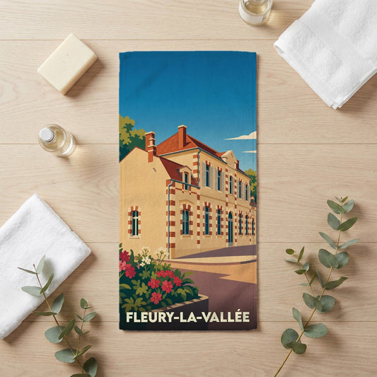 Serviette de bain souvenir de la ville de Fleury-la-Vallée avec une illustration stylisée d'un bâtiment traditionnel.