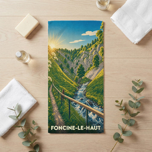 Serviette de bain souvenir de la ville de Foncine-le-Haut avec une illustration stylisée de paysage montagneux.