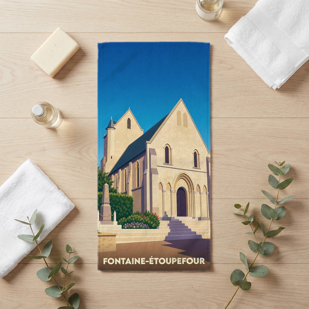 Serviette de bain souvenir de Fontaine-Étoupefour avec une illustration stylisée de son église.