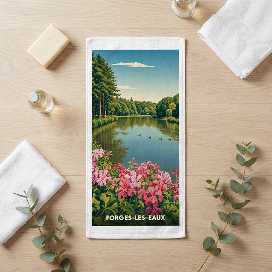 Serviette de bain souvenir de Forges-les-Eaux illustrée d'un paysage de lac bordé de fleurs roses.