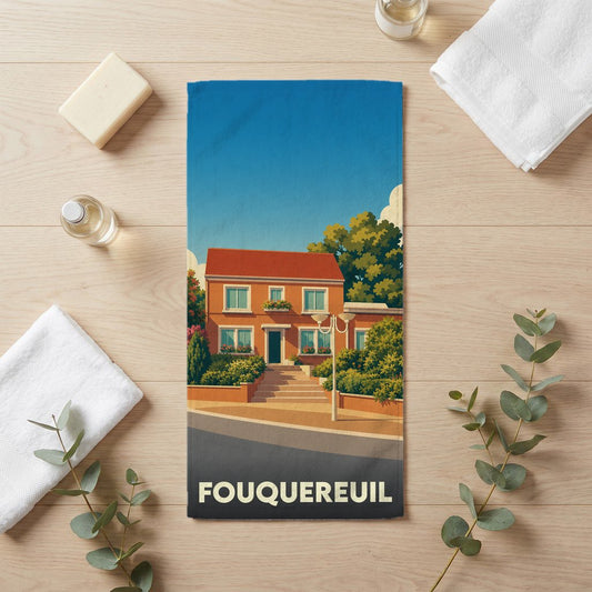 Serviette de bain souvenir de la ville de Fouquereuil avec une illustration stylisée d'une maison.