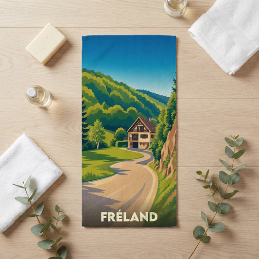 Serviette de bain souvenir de la ville de Fréland avec une illustration stylisée de paysage montagneux.