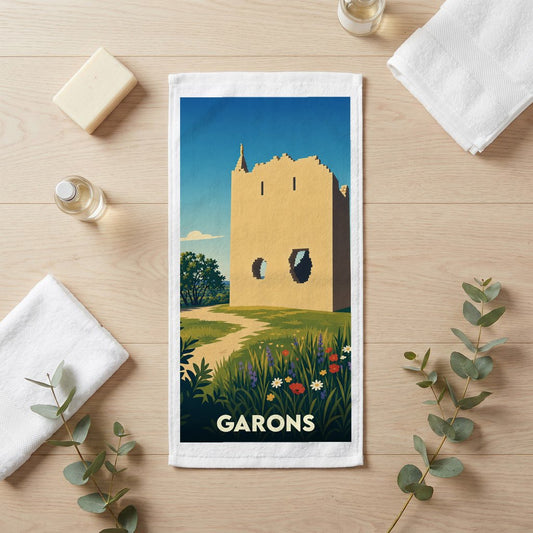 Serviette de bain souvenir de la ville de Garons illustrant un paysage de tour ancienne et de fleurs sauvages.