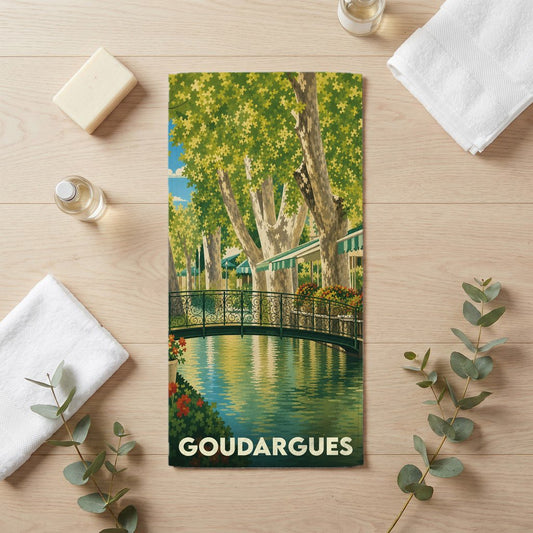 Serviette de bain souvenir de la ville de Goudargues illustrée par une vue bucolique d'un canal et de ses platanes.
