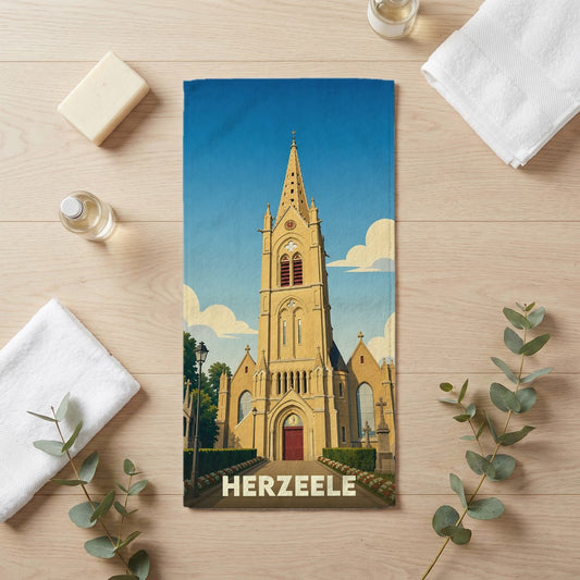 Serviette de bain souvenir de la ville de Herzeele illustrée d'une église de style néogothique sous un ciel bleu.