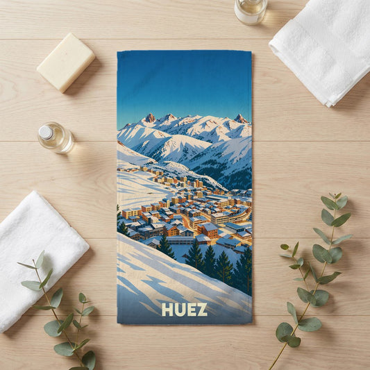 Serviette de bain souvenir de la ville de Huez illustrée par un paysage de montagne enneigé.