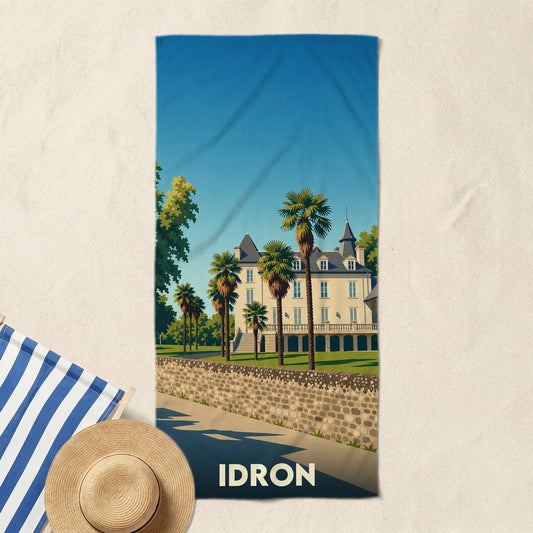 Serviette de bain souvenir de la ville d'Idron avec une illustration stylisée d'un château et de palmiers.