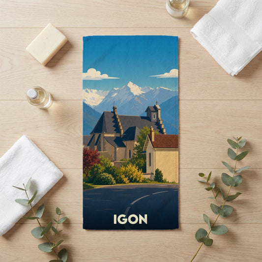 Serviette de bain souvenir de la ville de Igon avec une illustration stylisée de son église devant les montagnes.
