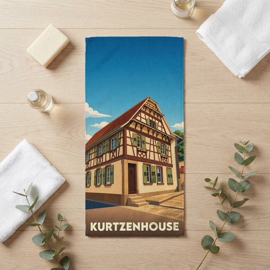 Serviette de bain souvenir de la ville de Kurtzenhouse avec une illustration stylisée d'une maison à colombages.