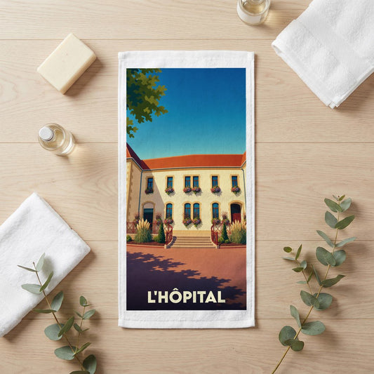 Serviette de bain souvenir de la ville de L'Hôpital avec une illustration stylisée d'un bâtiment fleuri.