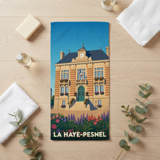 Serviette de bain souvenir de la ville de La Haye-Pesnel avec une illustration stylisée de son hôtel de ville.