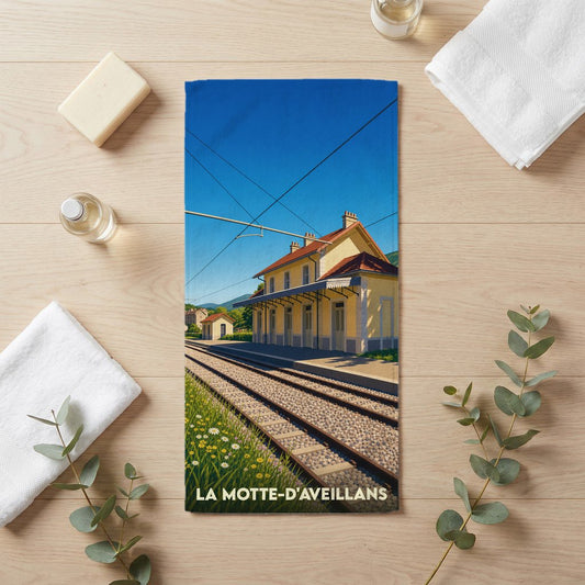 Serviette de bain souvenir de la ville de La Motte-d'Aveillans avec une illustration stylisée de sa gare ferroviaire.