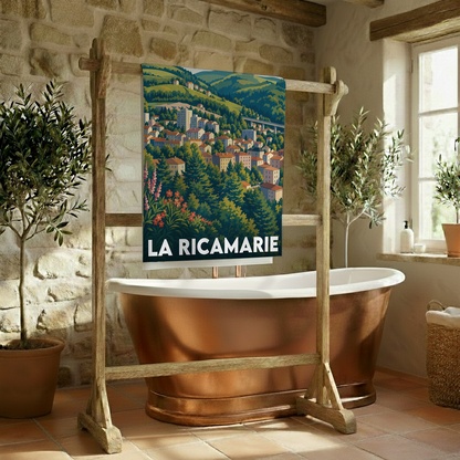 Serviette de bain souvenir de la ville de La Ricamarie ornée d'une illustration de paysage urbain et collinaire stylisée.