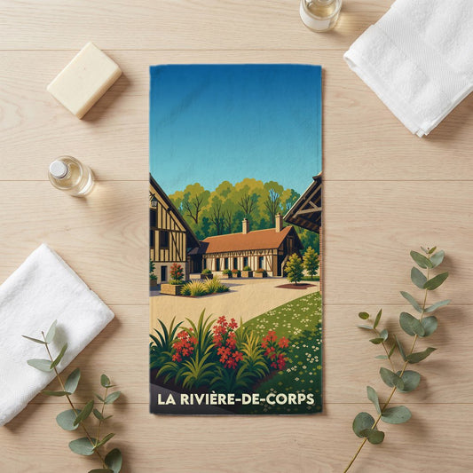 Serviette de bain souvenir de la ville de La Rivière-de-Corps avec une illustration stylisée de maisons à colombages.
