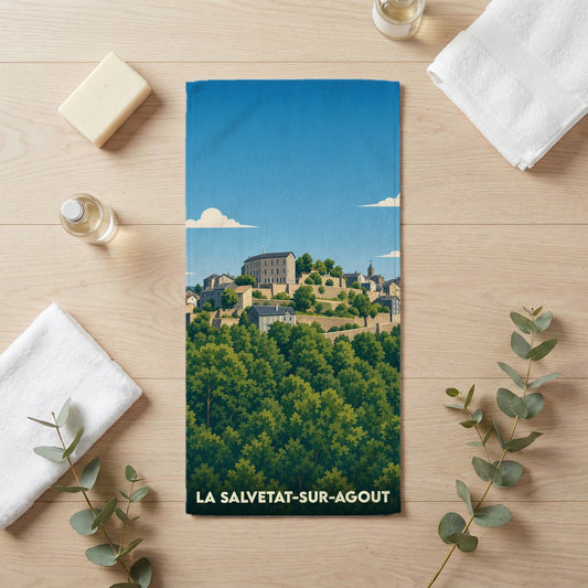 Serviette de bain souvenir de La Salvetat-sur-Agout illustrant le village perché au-dessus d'une forêt.