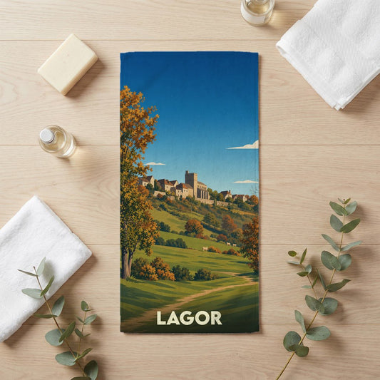 Serviette de bain souvenir de la ville de Lagor illustrant un paysage de village vallonné dans un style rétro.