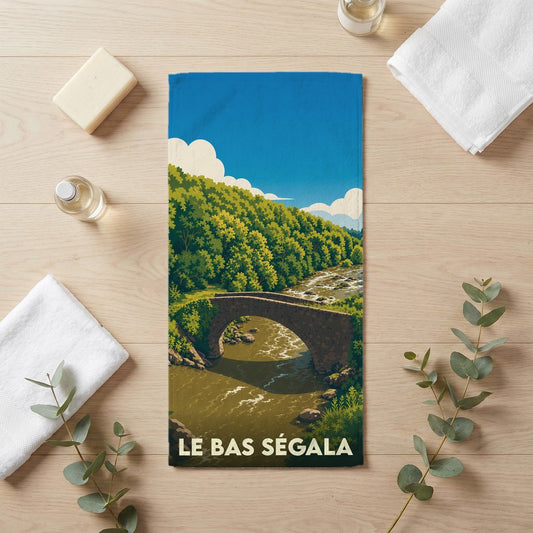 Serviette souvenir de la ville de Le Bas Ségala avec une illustration stylisée d'un pont en pierre.