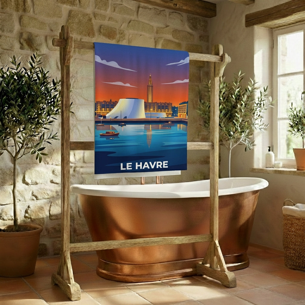Serviette de bain souvenir de la ville de Le Havre avec une illustration stylisée de son architecture et de son port au coucher du soleil.