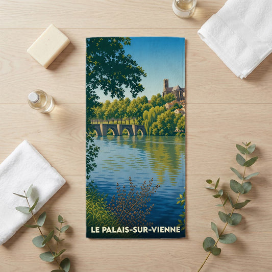 Serviette de bain souvenir de la ville de Le Palais-sur-Vienne avec une illustration stylisée d'un pont et d'une cathédrale au bord de l'eau.