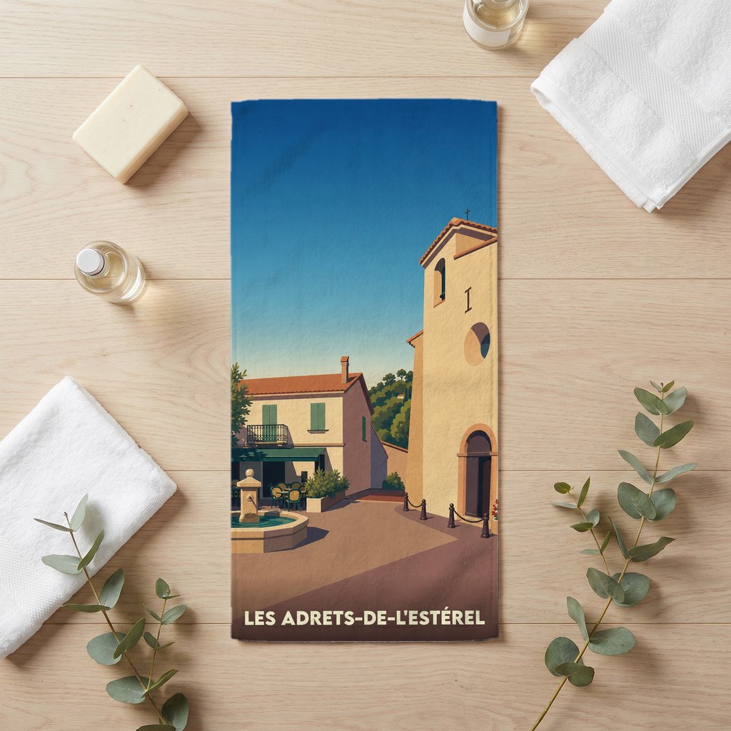 Serviette de bain souvenir de la ville de Les Adrets-de-l'Estérel avec une illustration stylisée d'une place provençale.