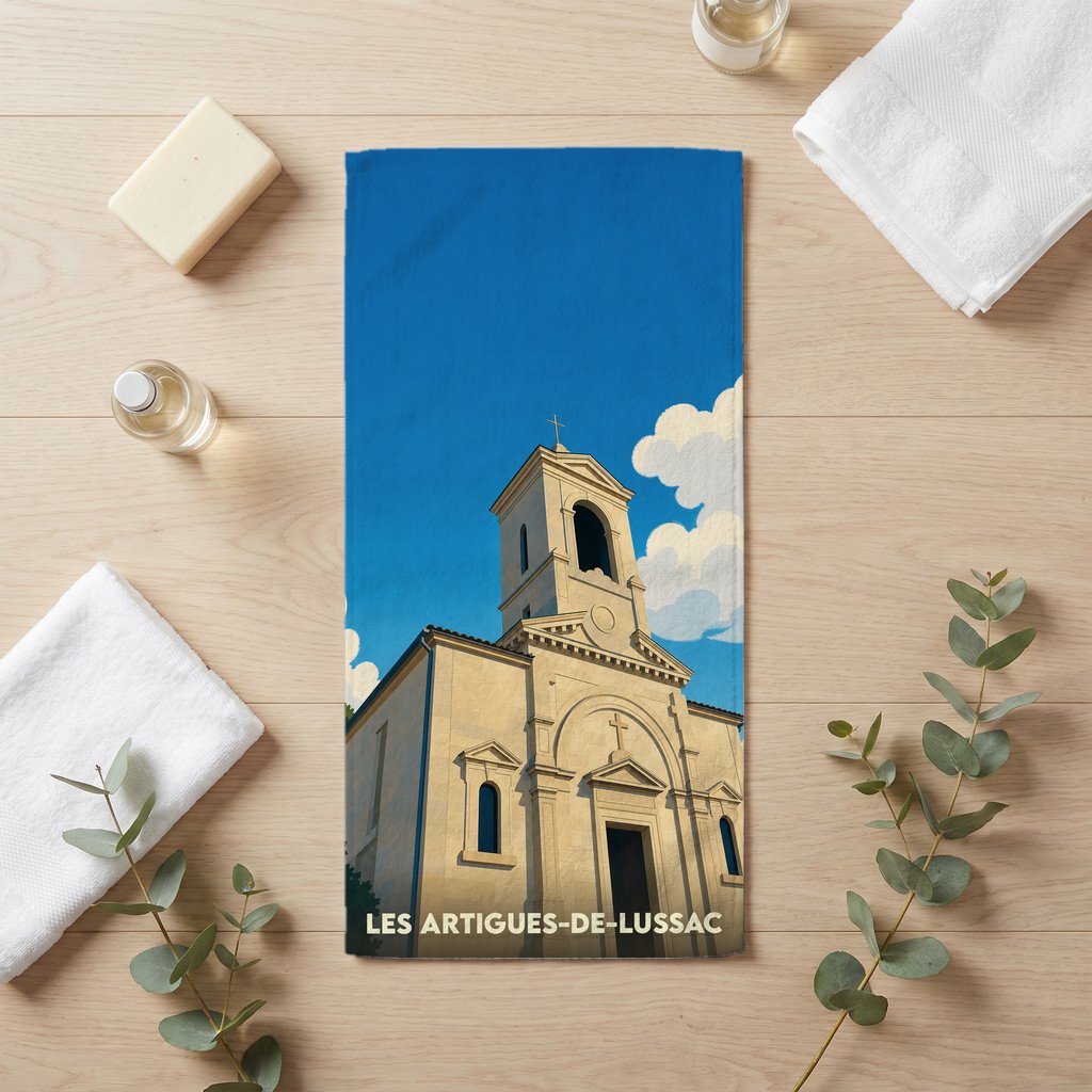 Serviette de bain souvenir de la ville de Les Artigues-de-Lussac avec l'illustration d'une église sous un ciel bleu.