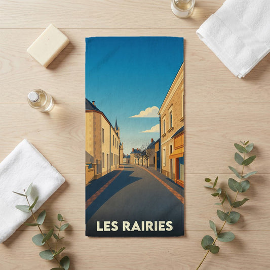 Serviette de bain souvenir de la ville de Les Rairies avec une illustration stylisée d'une rue pittoresque.