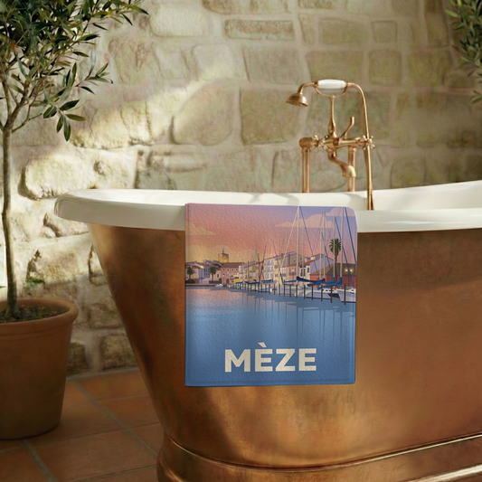 Serviette de bain souvenir de la ville de Mèze avec une illustration stylisée.