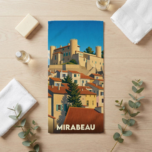 Serviette de bain souvenir de la ville de Mirabeau avec une illustration stylisée d'un village provençal et de son château.